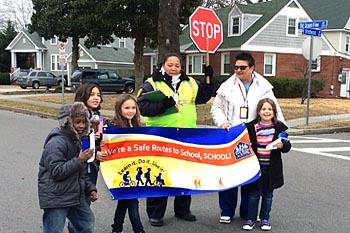 Crossing guard with kids holding a banner